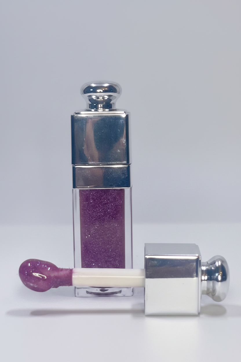 Lip gloss with purple shade and silver cap on a white background